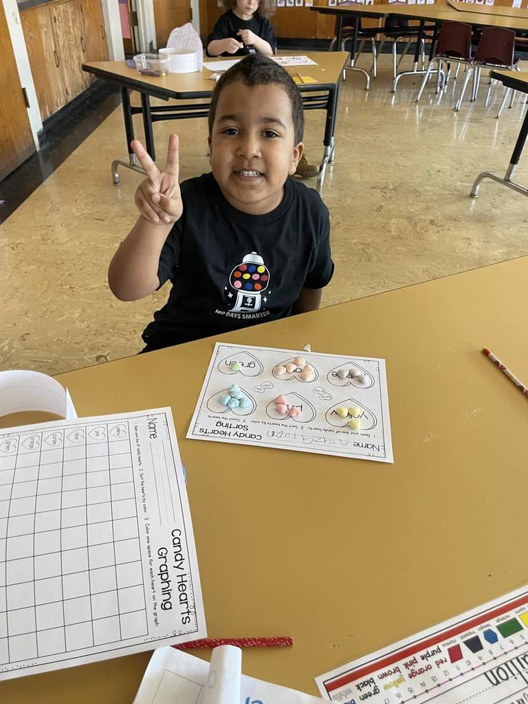 Student doing an activity in class, using candy and paper. 