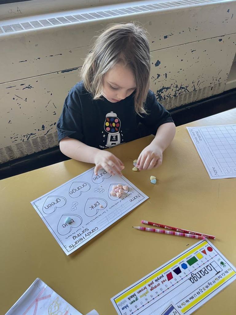 Student doing an activity in class, using candy and paper. 