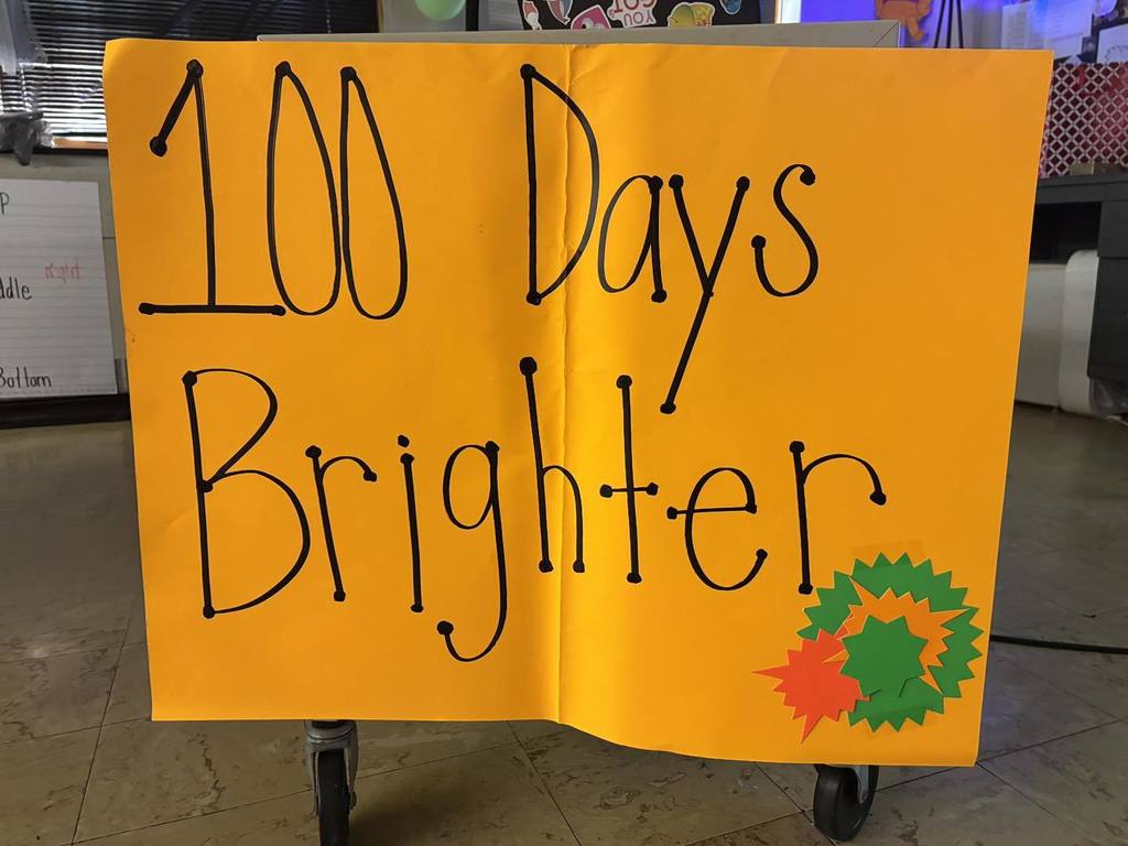 100 Days Brighter written on a bright orange poster. 