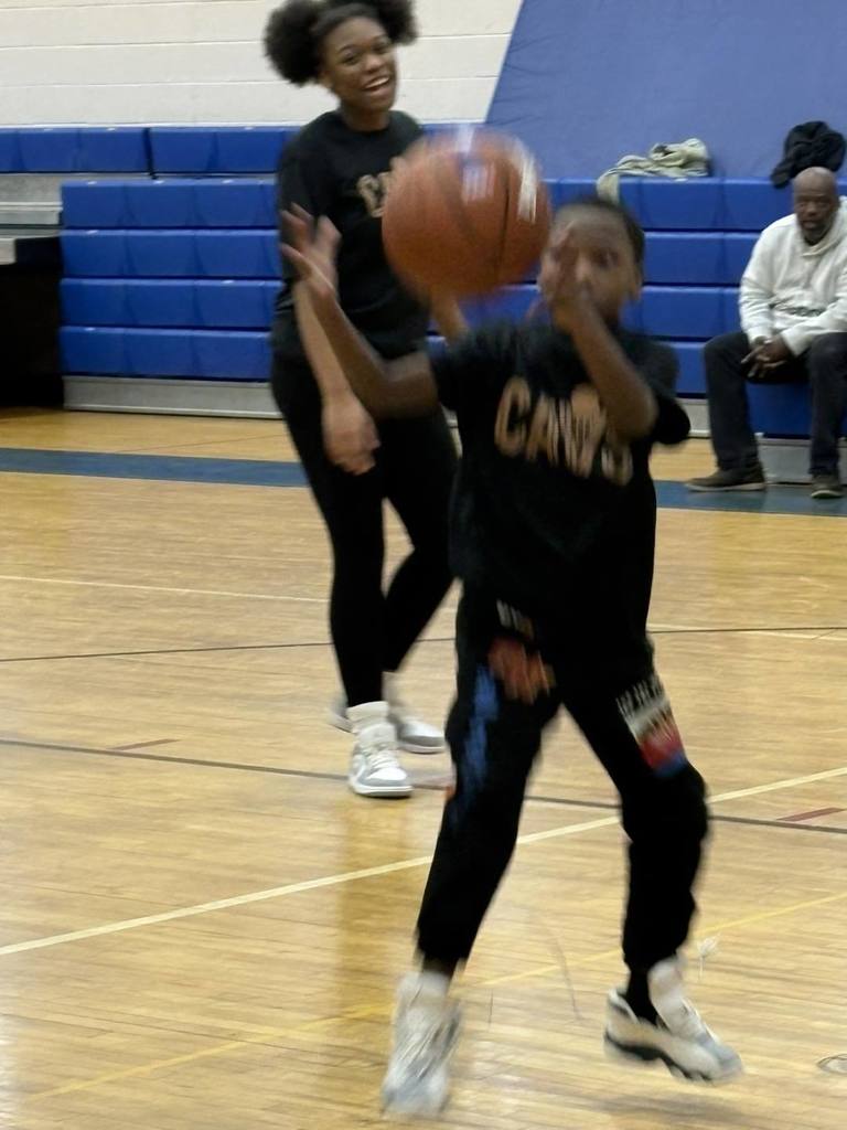Students wearing black shirts are playing basketball. 