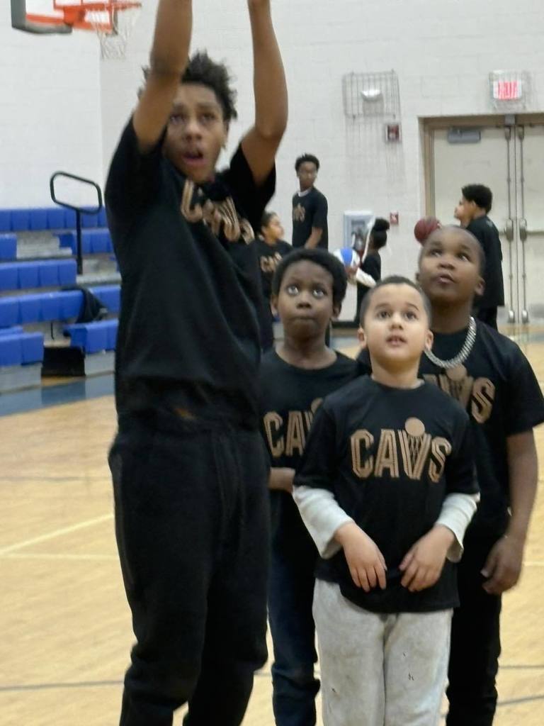 Students wearing black shirts are playing basketball. 
