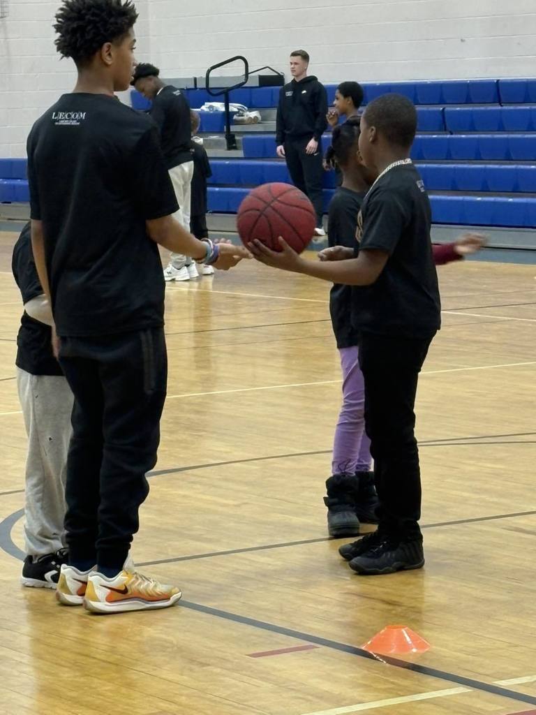 Students wearing black shirts are playing basketball. 