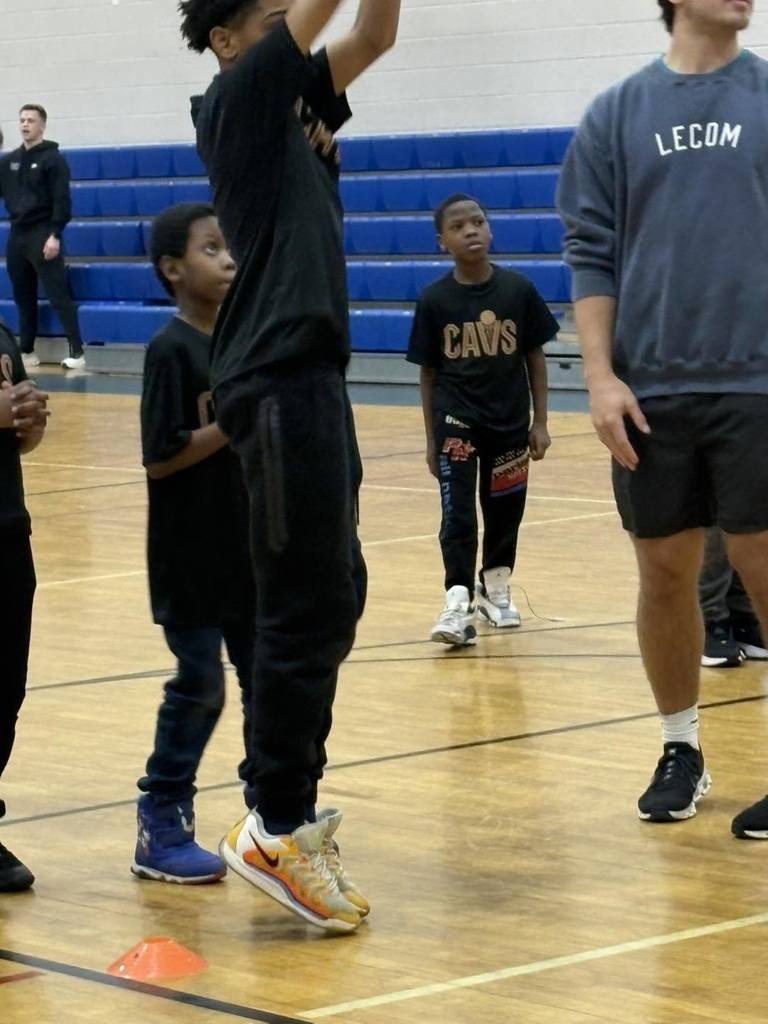 Students wearing black shirts are playing basketball. 