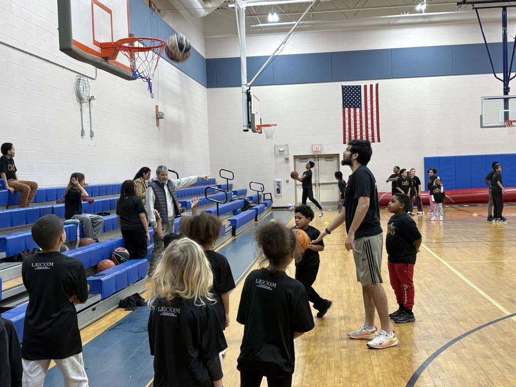 Group of students and adults playing basketball. 