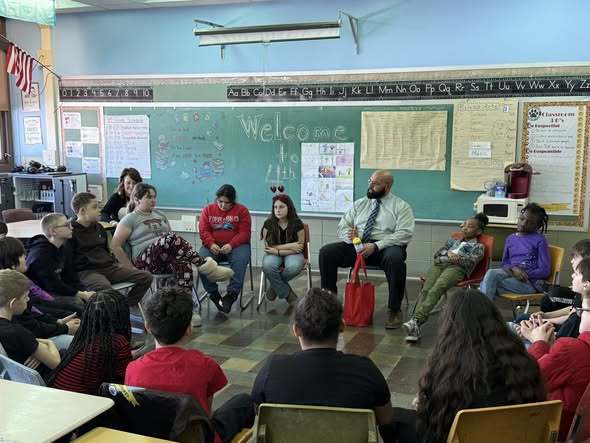 A man talking to kids in a classroom.
