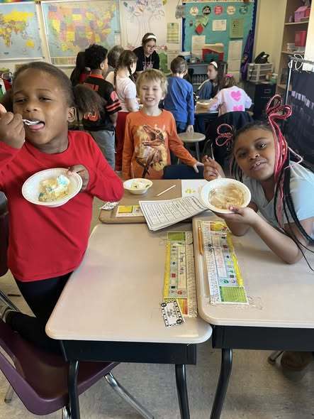 Students eating ice cream in bowls. 