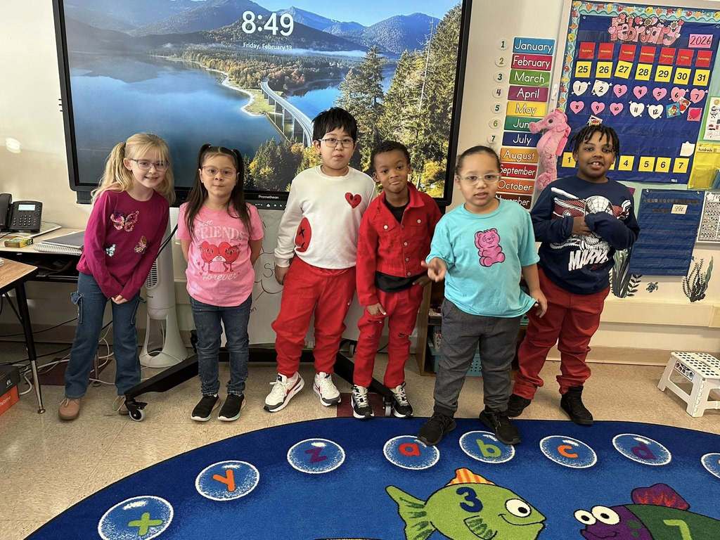 A group of students wearing pink and red.