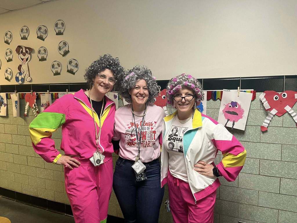 Three teachers dressed as old women and wearing bright clothing.