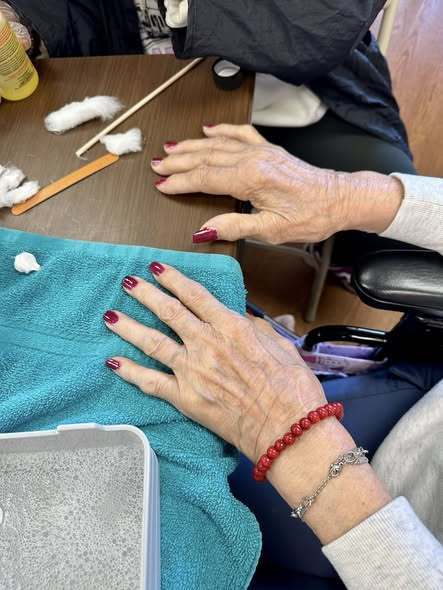 Woman's hands and her nails are painted red.
