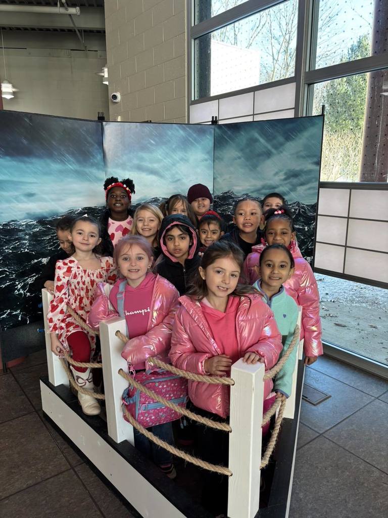Kids standing on half a boat with a backdrop of a stormy sea. 