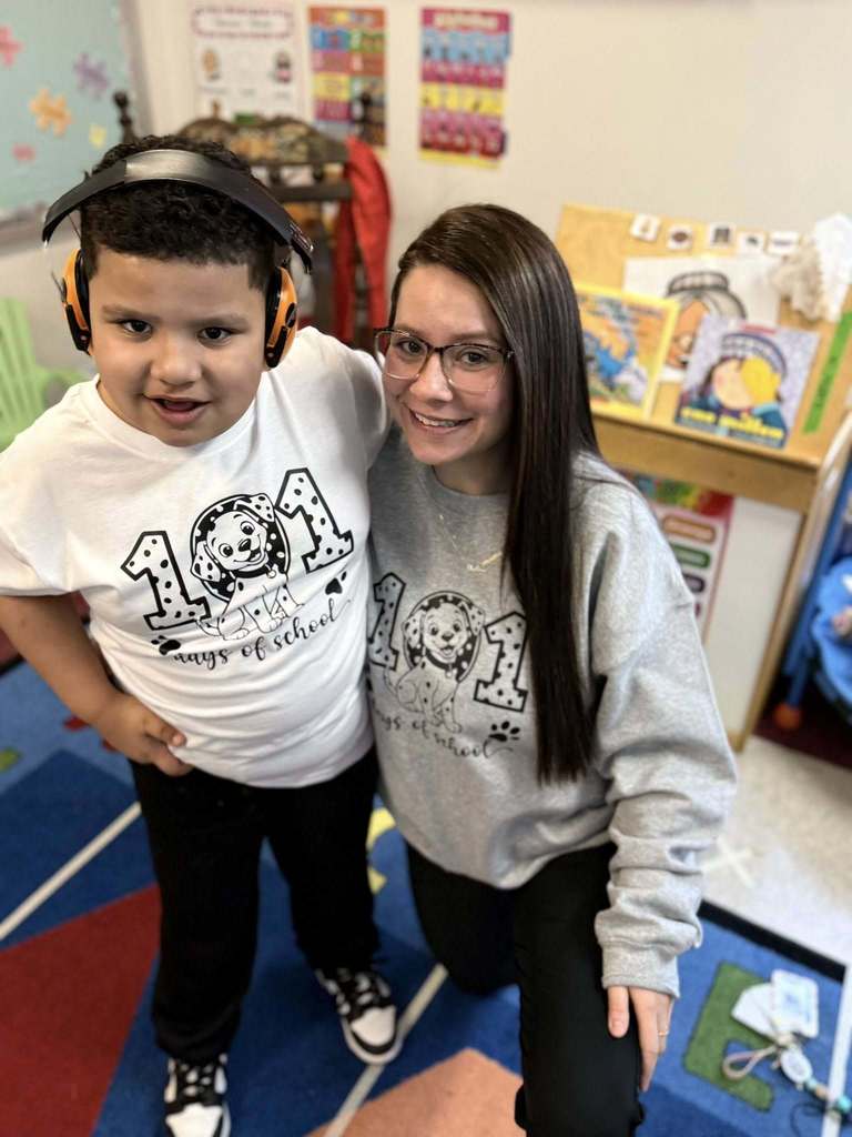 A teacher and student wearing shirts that recognize that it is the 101 day of school. 