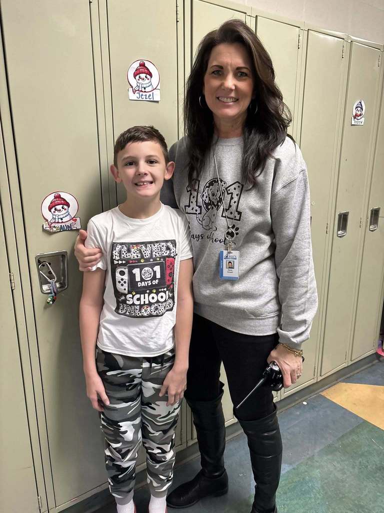 A teacher and student wearing shirts that recognize that it is the 101 day of school. 