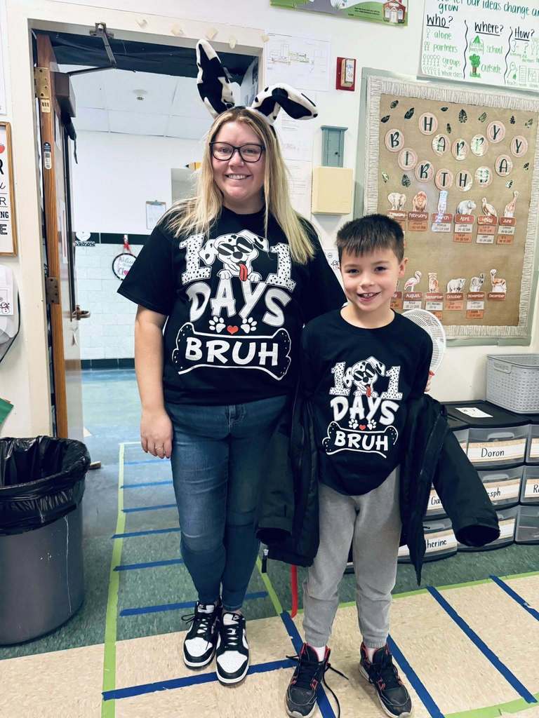 A teacher and student wearing shirts that recognize that it is the 101 day of school. 