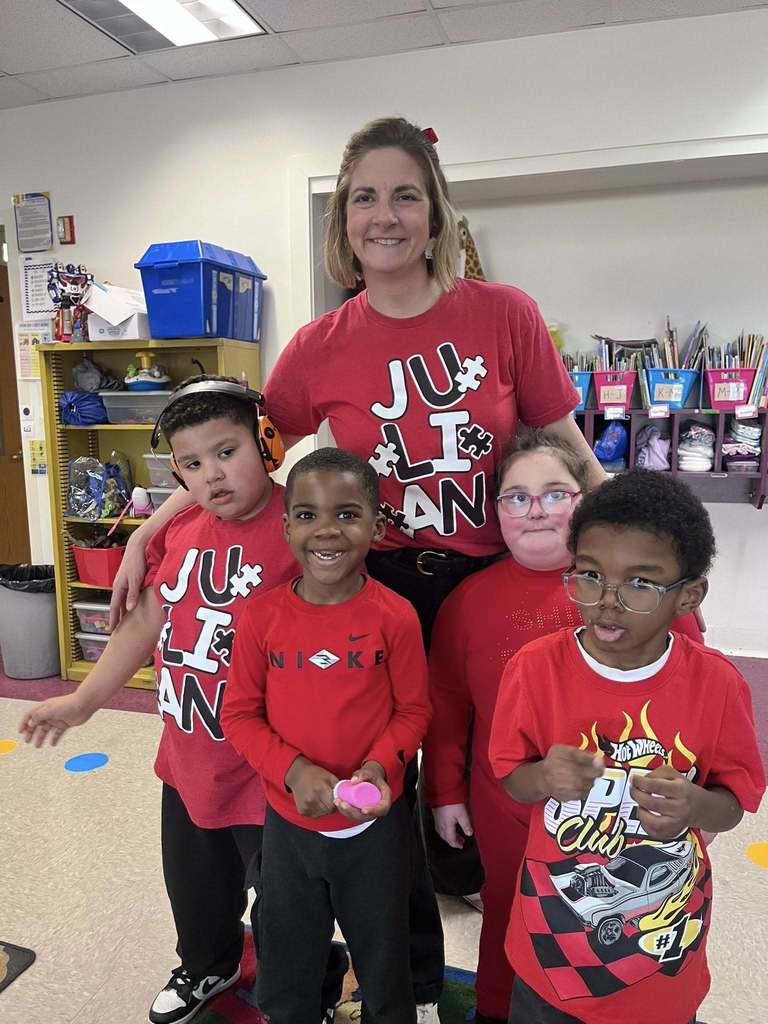 A teacher and students dressed in red. 
