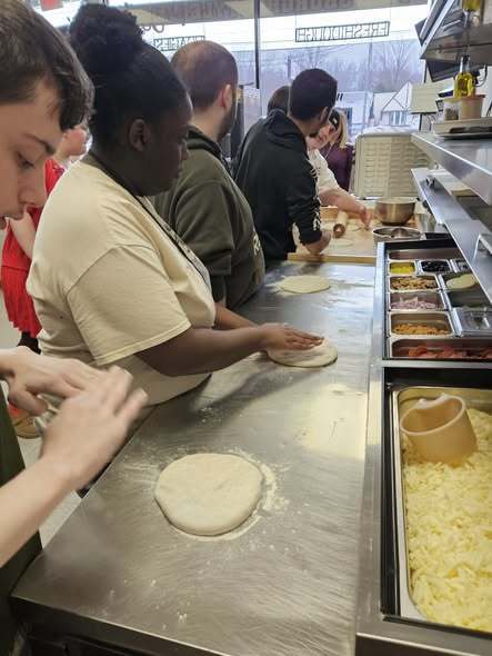 Students learning how to make fresh pizza.