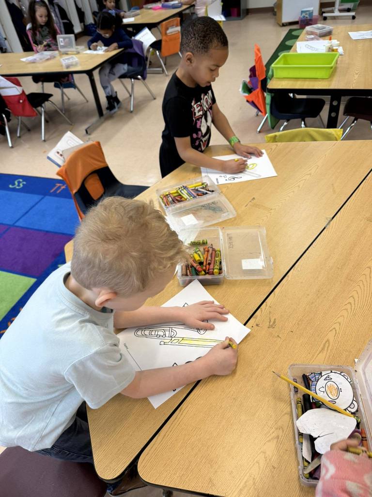 Kids coloring a drawing of a trombone.
