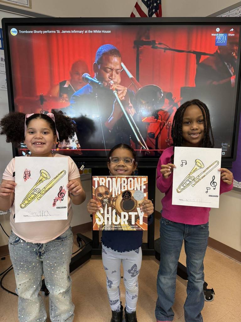 Kids holding paper with a trombone they colored on it.