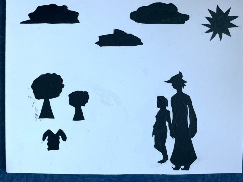 An art piece of the silhouette cut-outs of people outside. 