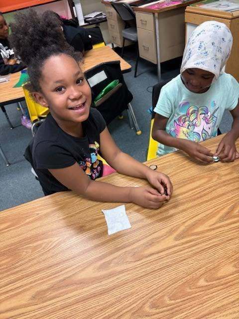 Two students sitting at a table and smiling.