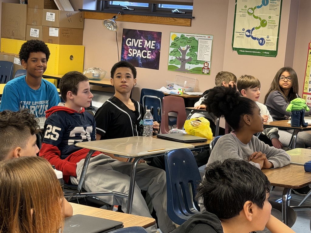 Students sitting at tables in the classroom.