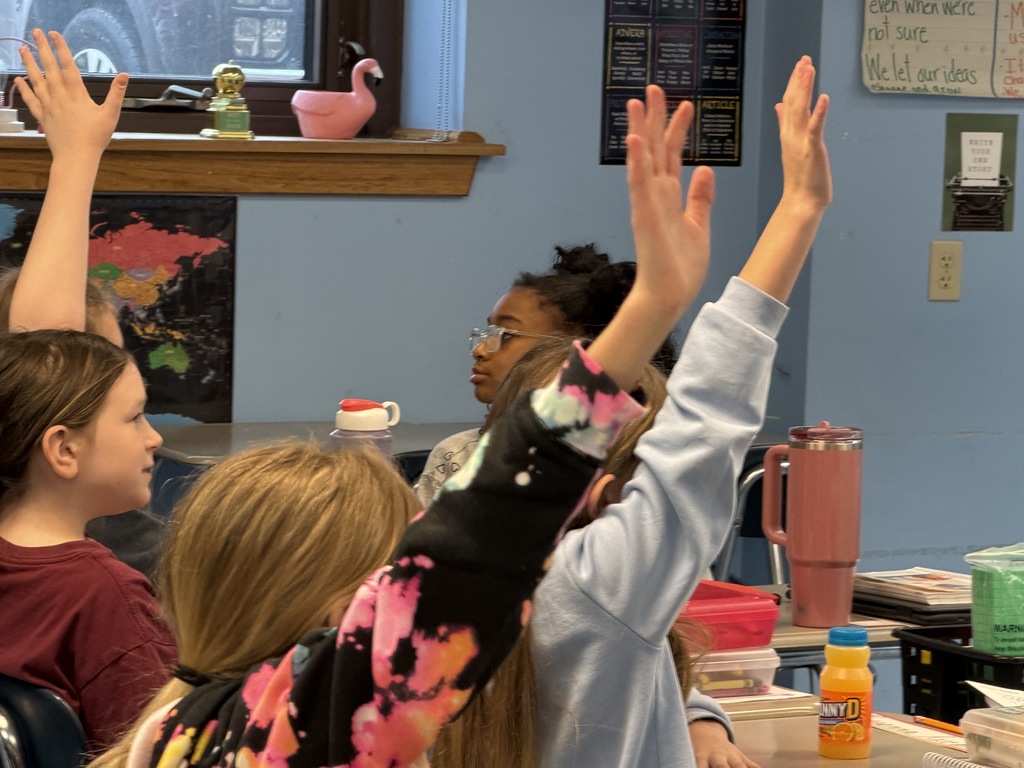 Kids raising their hands in class to ask questions.