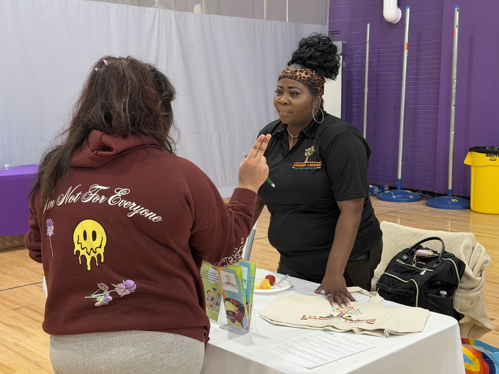Students talking to different companies at a career fair.