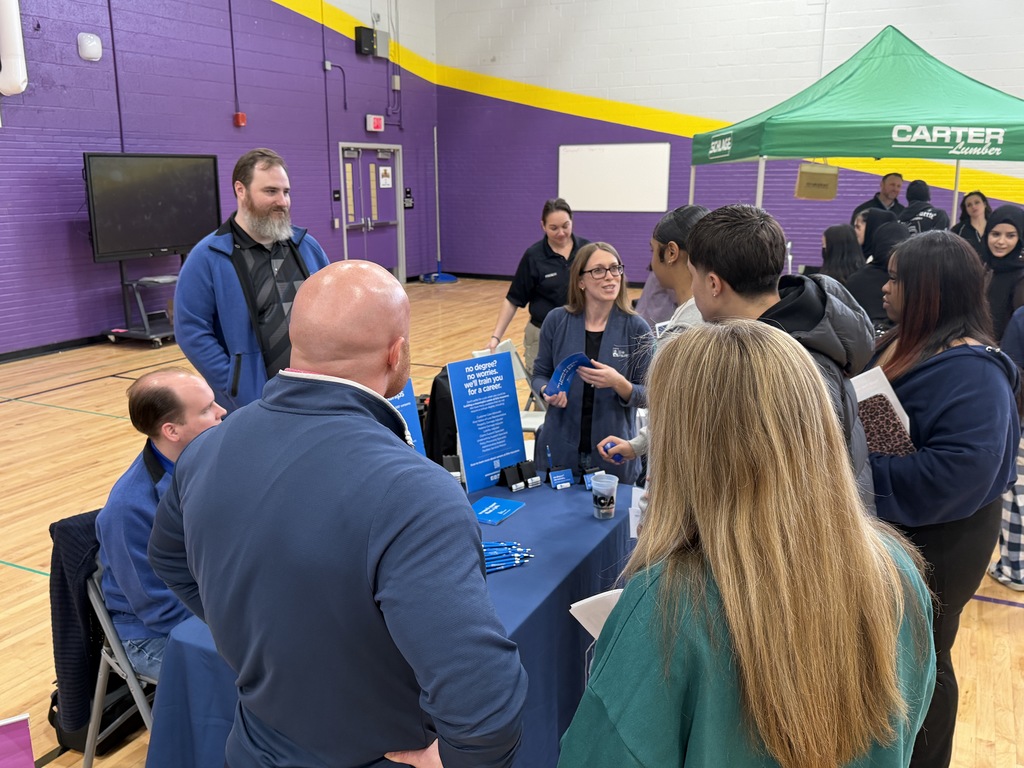 Students talking to different companies at a career fair.