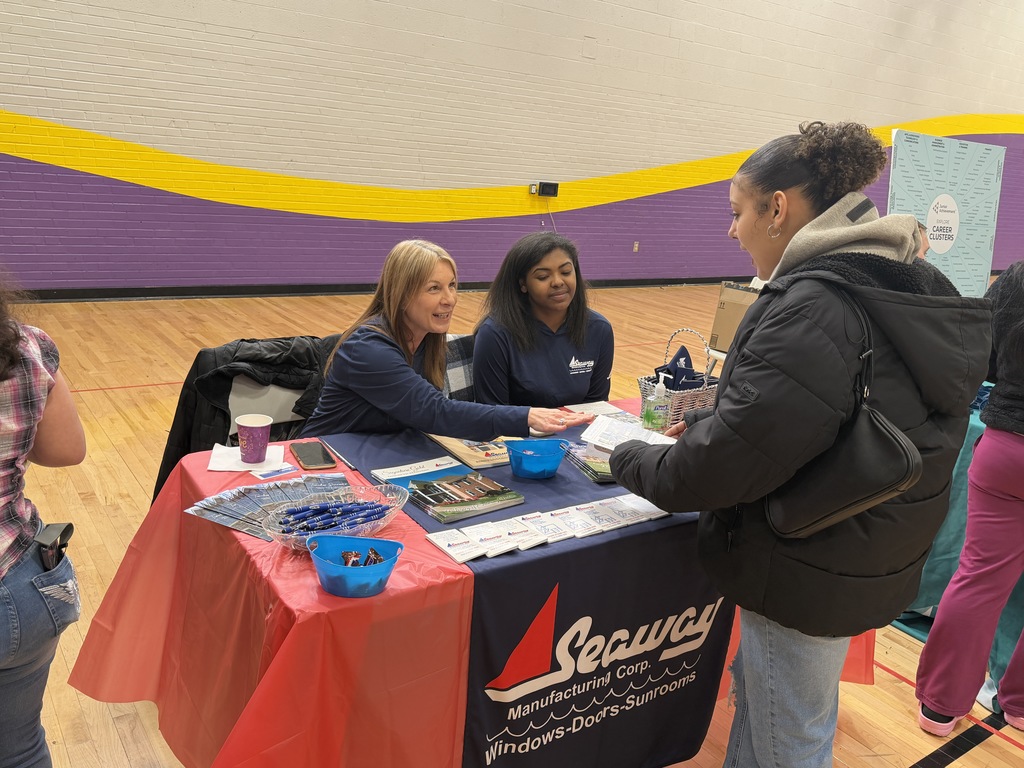 Students talking to different companies at a career fair.