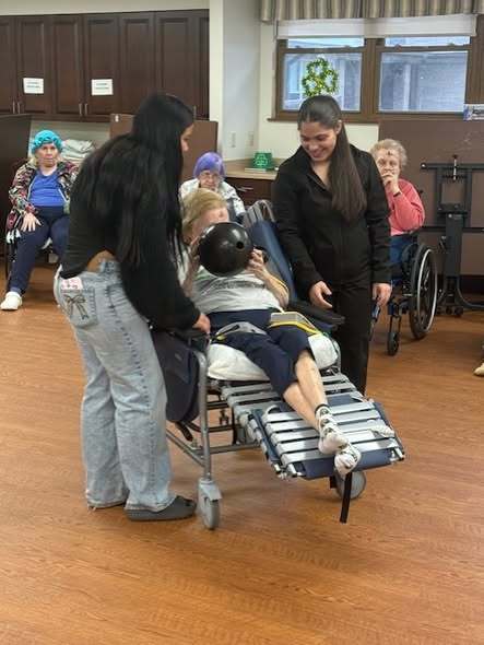 Students interacting with elderly individuals in a nursing home.