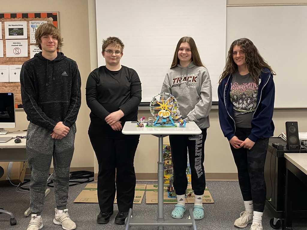 High School Student gathered around a table full of Legos.