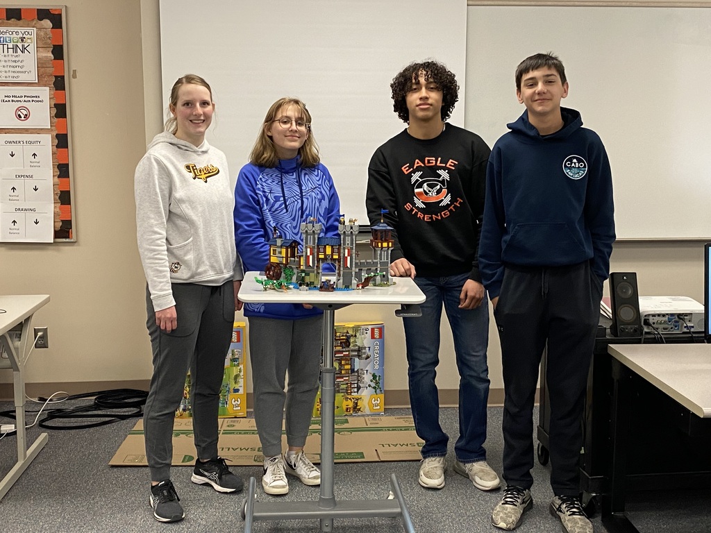 High School Student gathered around a table full of Legos.