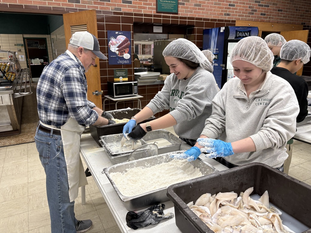 Students volunteering to bread fish filets and onion rings