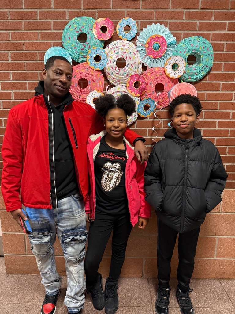 Two kids standing with a male adult.