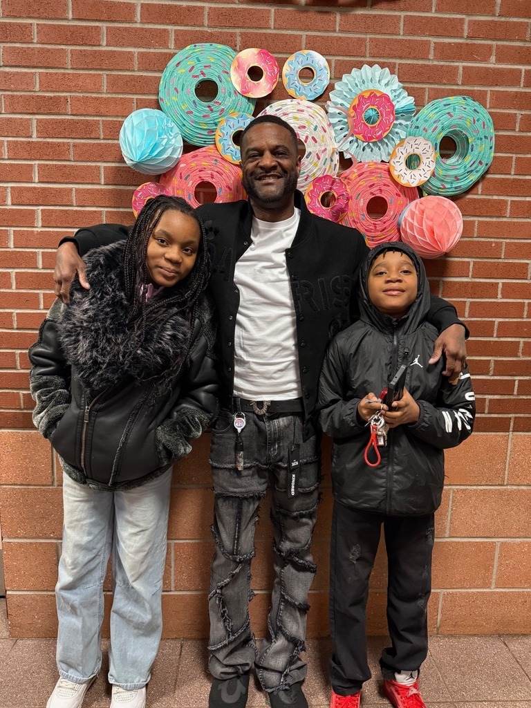 Two kids standing with a male adult.