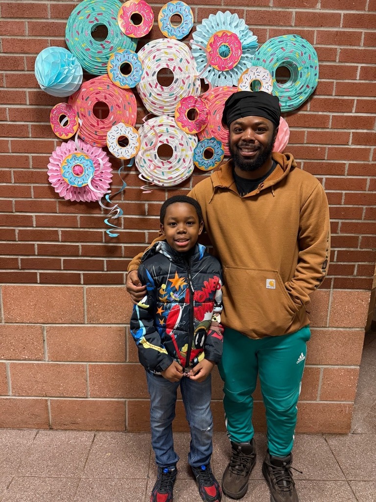 A kid standing with a male adult.