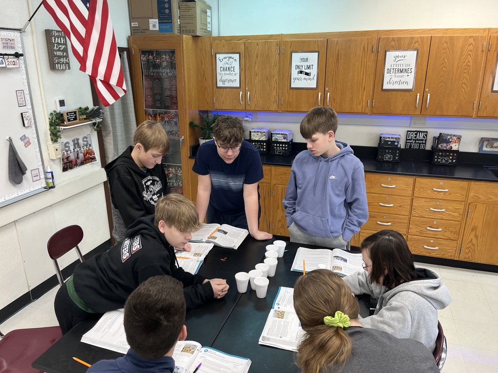 Students together analyzing the use of natural resources and recording their findings 