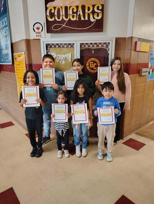 Group of students holding up their paper awards. 