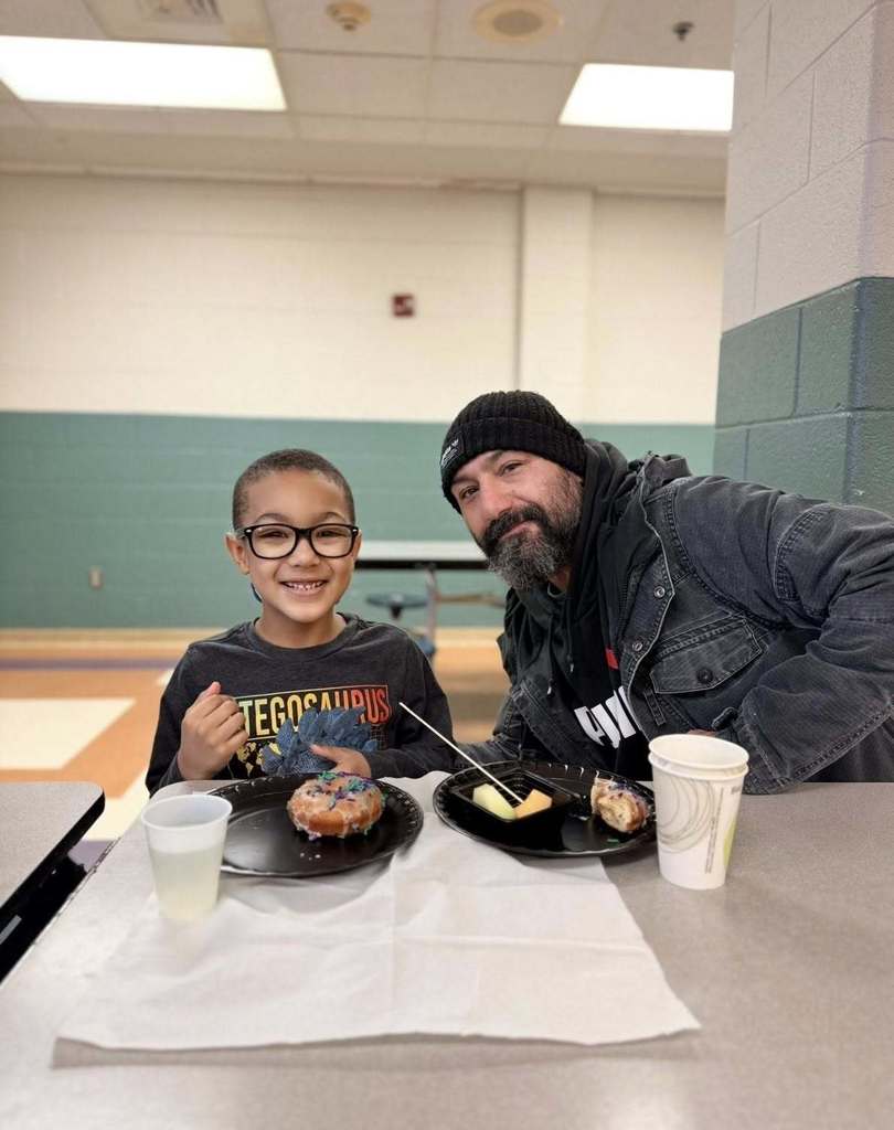 A student with their family eating breakfast at school.