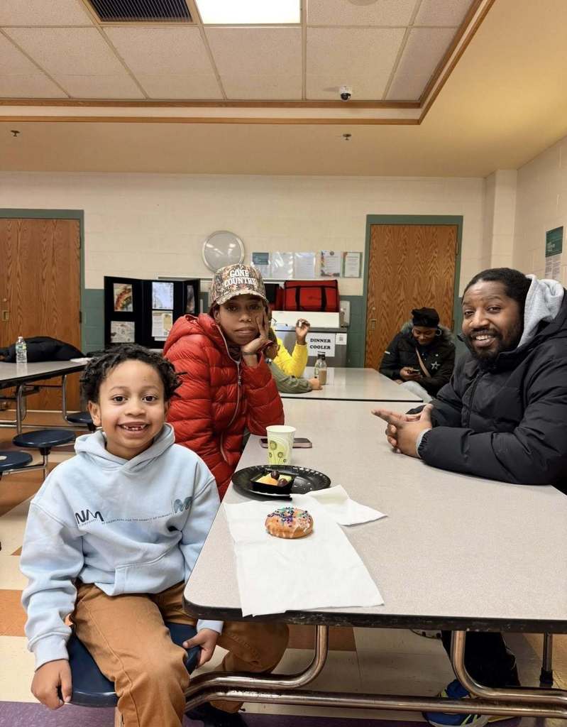 A student with their family eating breakfast at school.