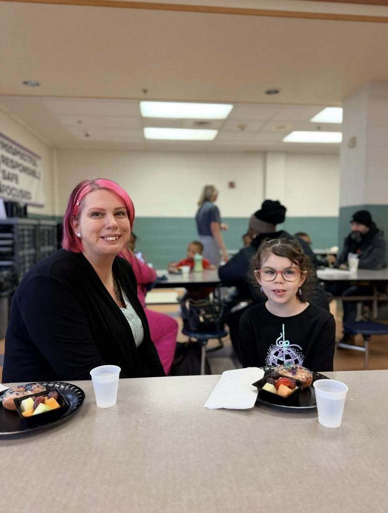 A student with their family eating breakfast at school.