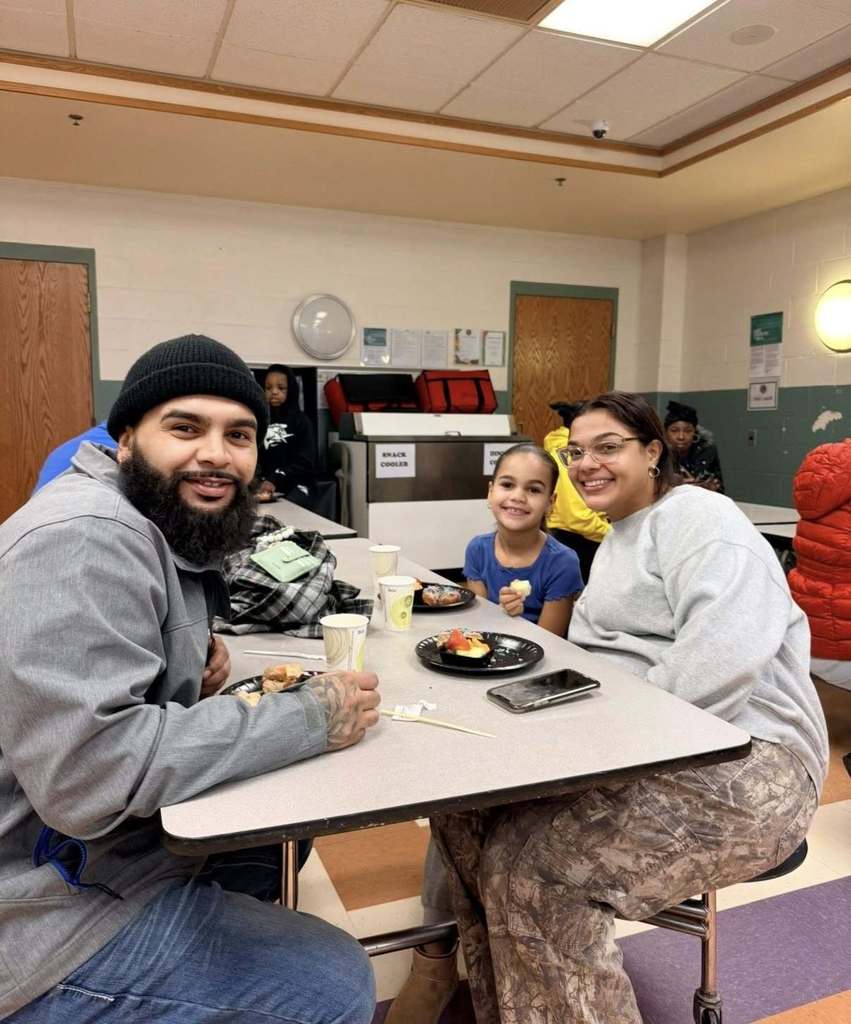 A student with their family eating breakfast at school.