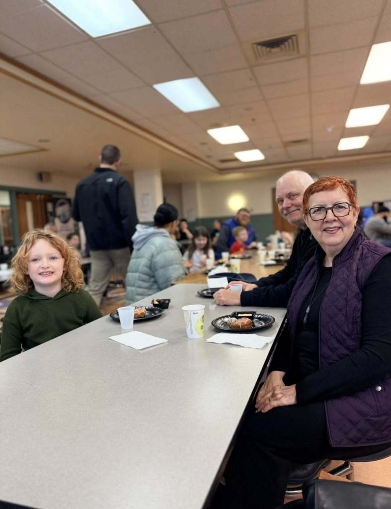 A student with their family eating breakfast at school.