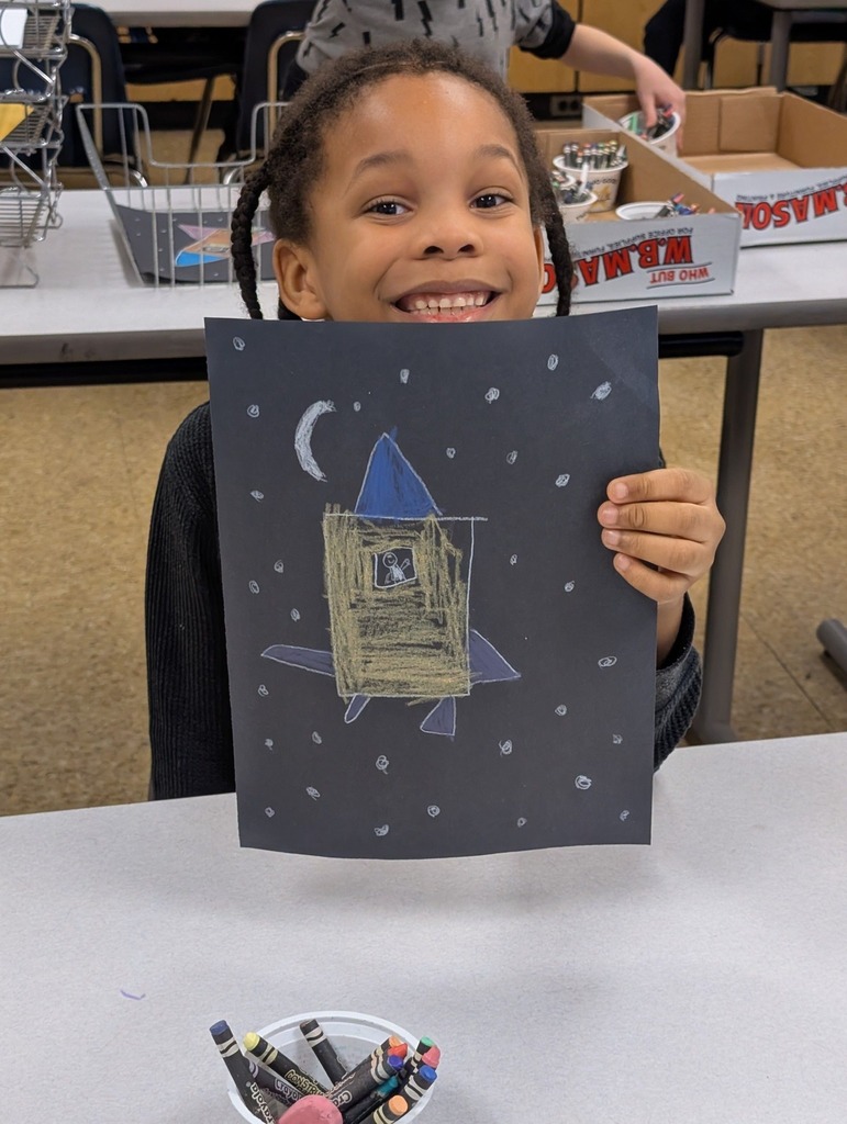 A student holding a rocket he drew. 