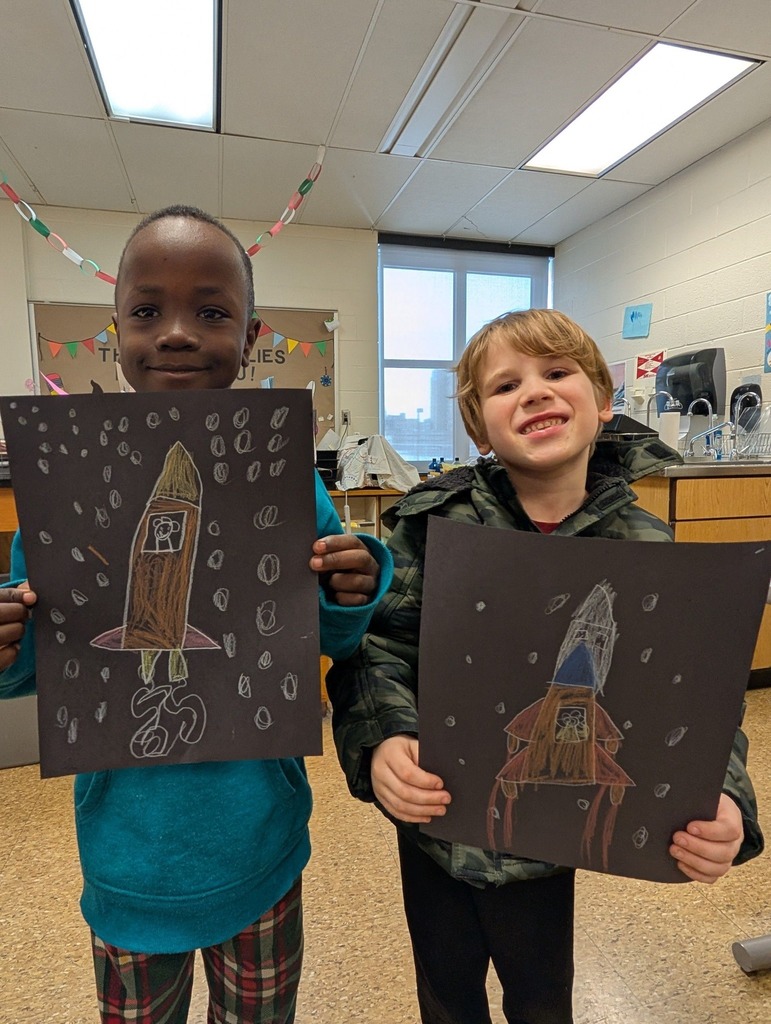 Student's holding rockets they drew. 