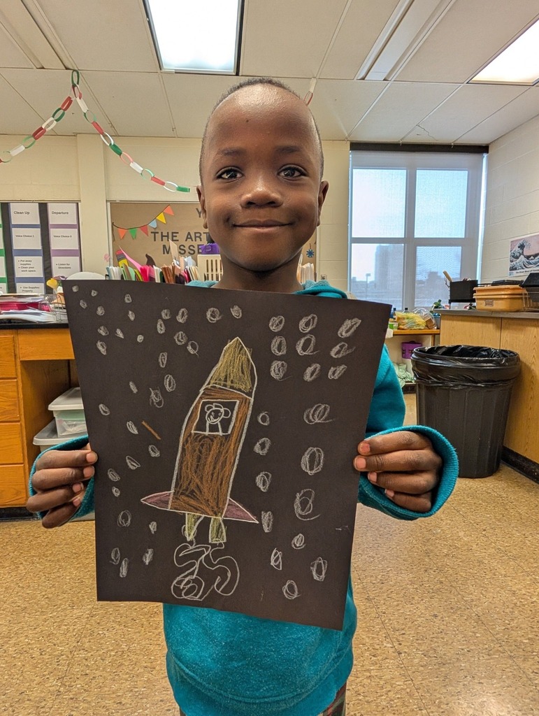 A student holding a rocket he drew. 