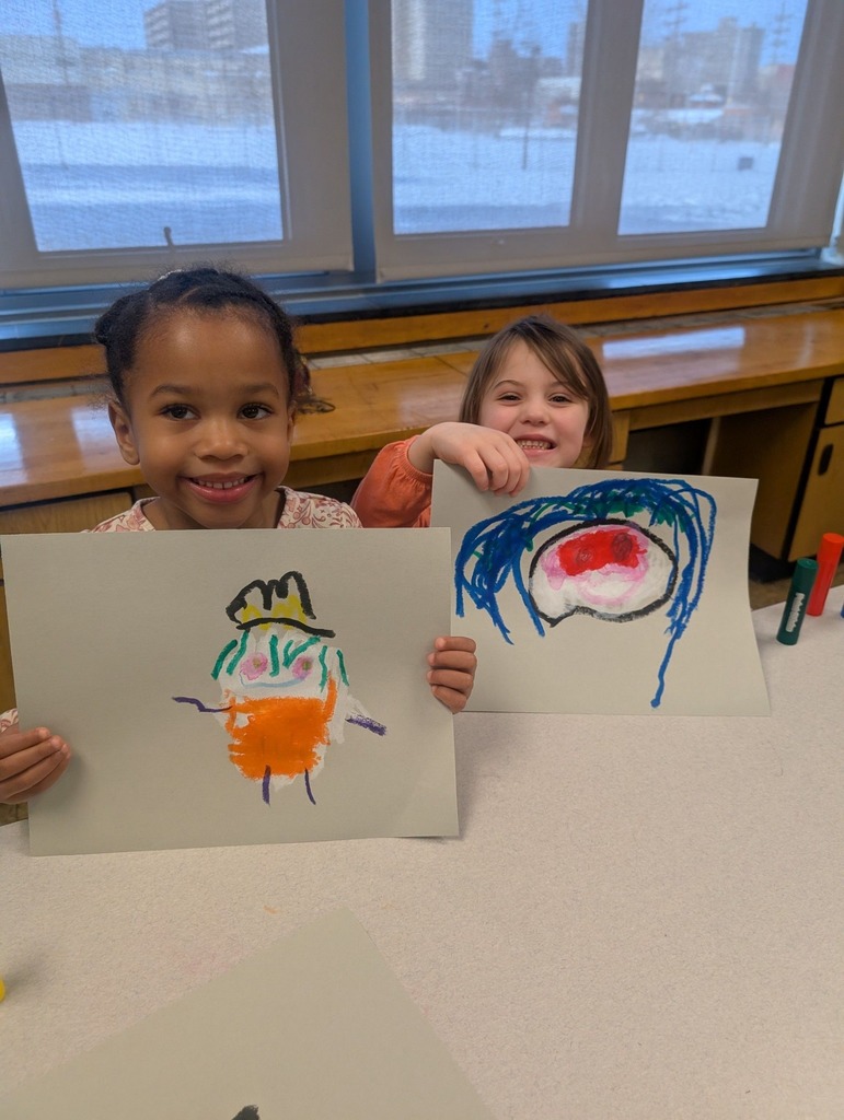 Students holding colorful art they created.
