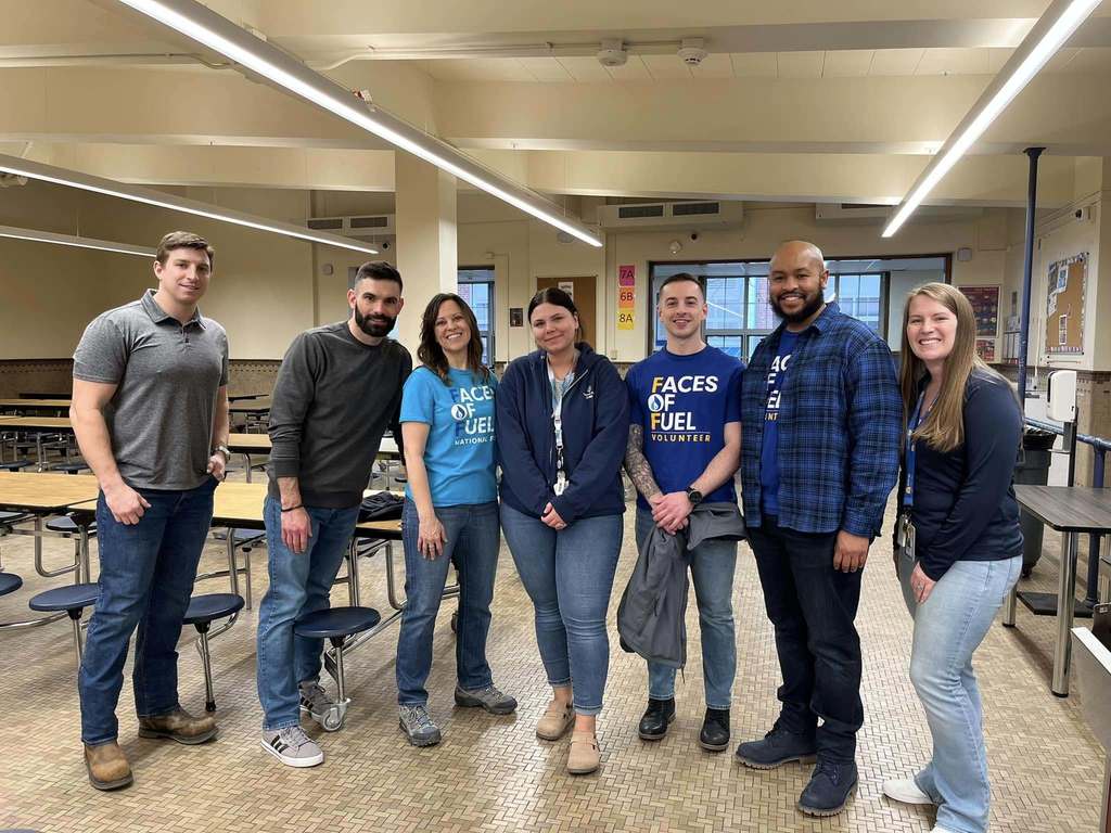 A group of teachers smiling in a school cafeteria.