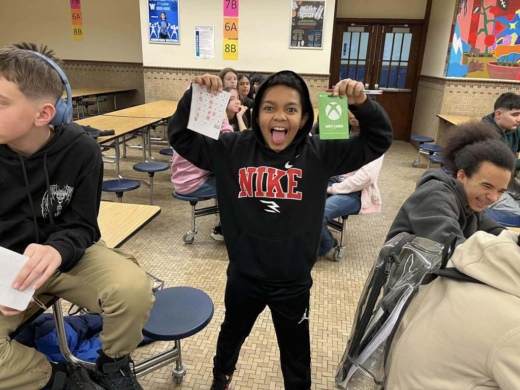 Student holding up his prize of a gift card for Xbox.