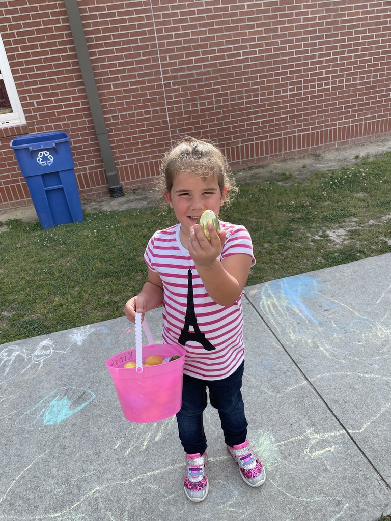 A little girl is showing that she found a golden egg during her Easter egg hunt.