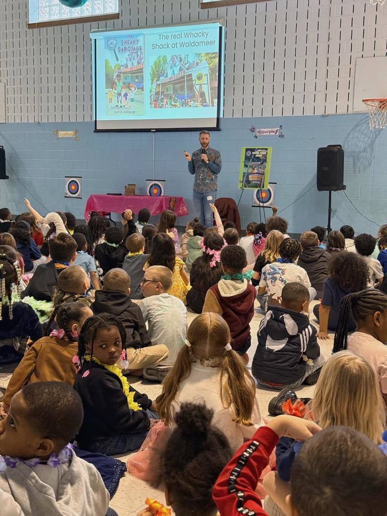  David Gorman speaking to kids and some kids have their hands raised.